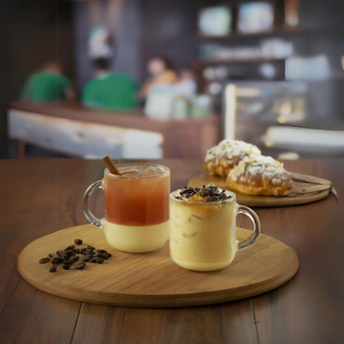 Juego de tazas San Miguel de vidrio en cafetería, ideales para bebidas frías o calientes con diseño moderno.