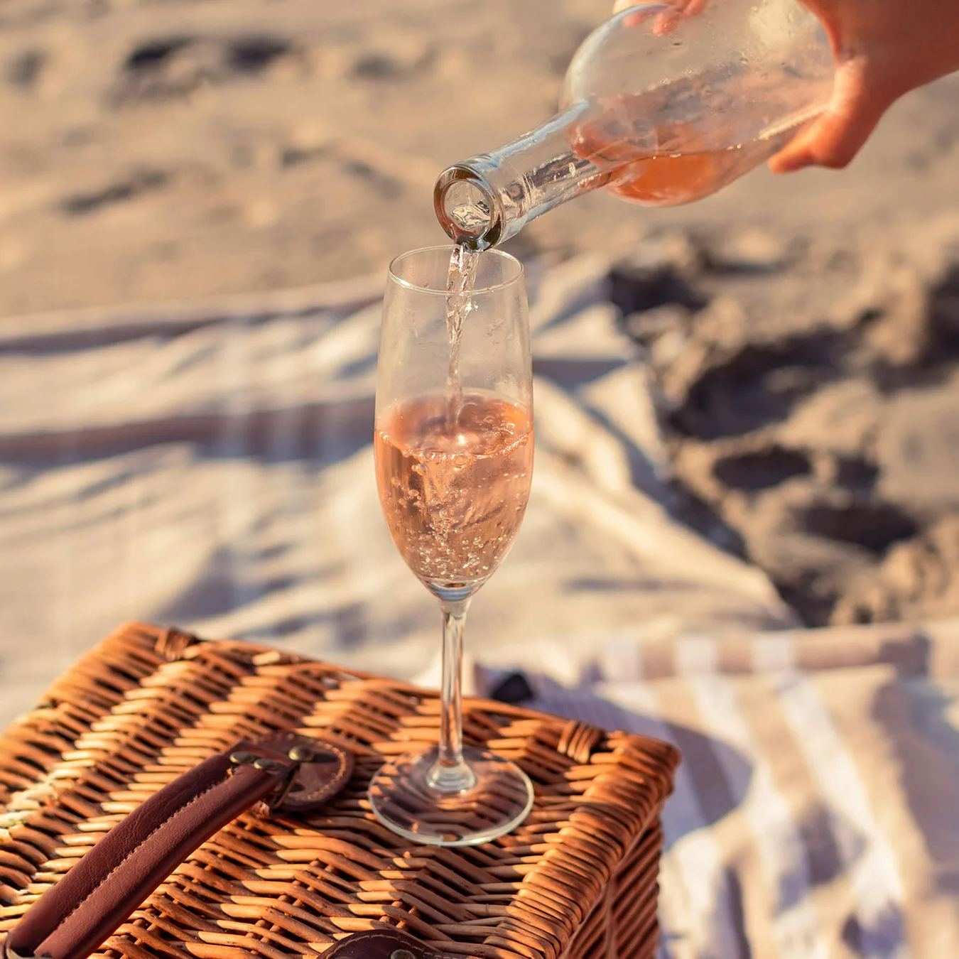 copa de vidrio en picnic en la playa con vino tinto buena iluminación.