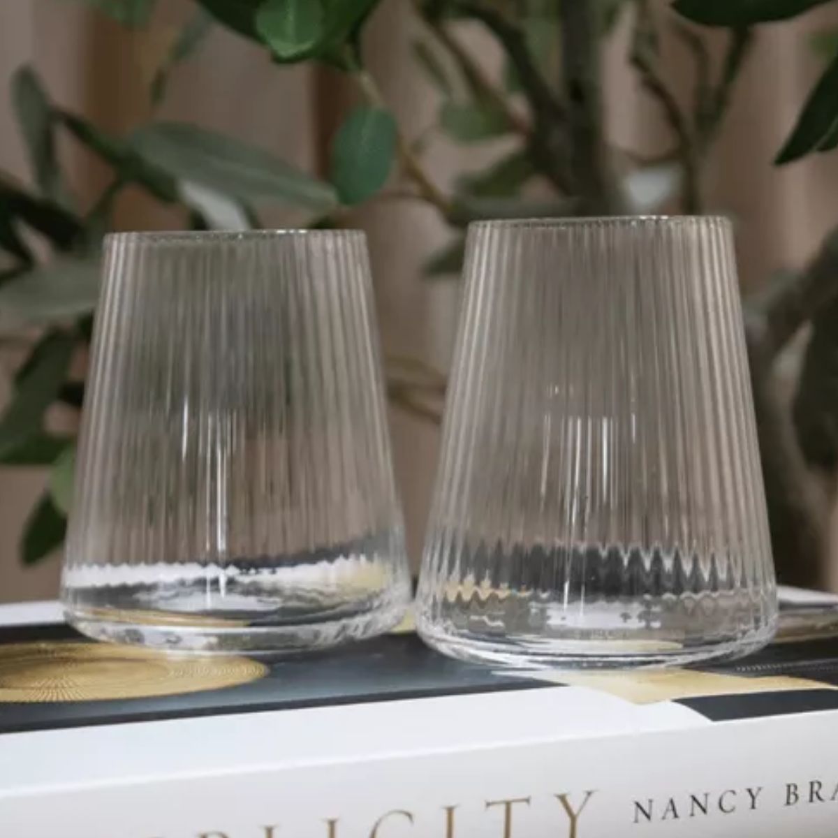 Vasos Lines de vidrio con líneas en relieve colocados sobre mesa interior