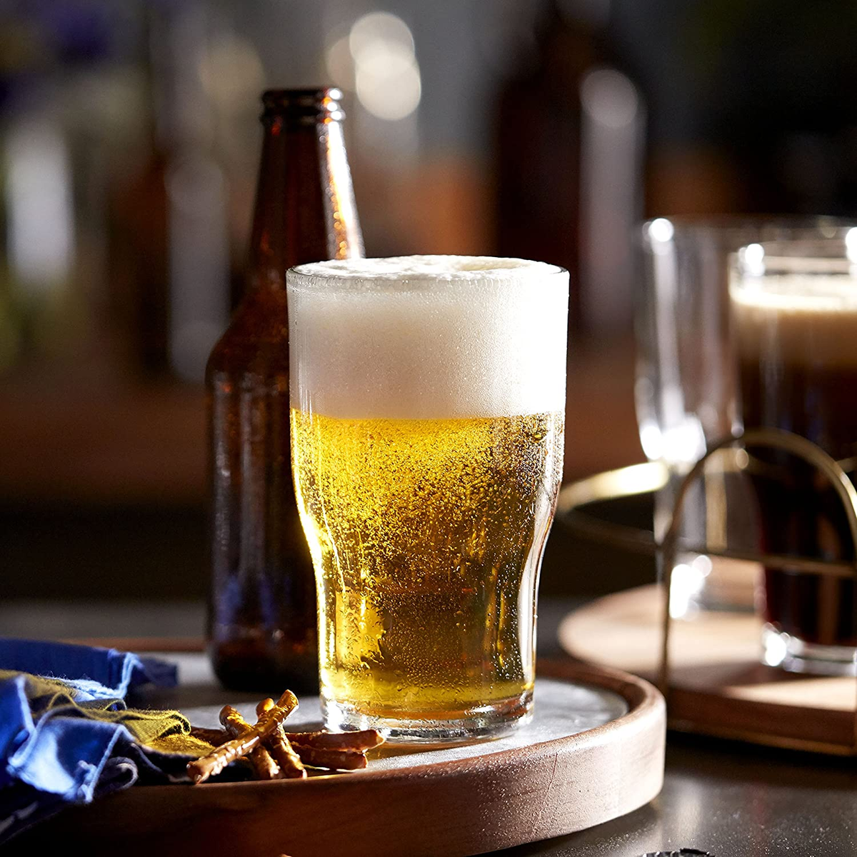 vaso de vidrio munich de vidrio con cerveza clara en el interior en un bar.