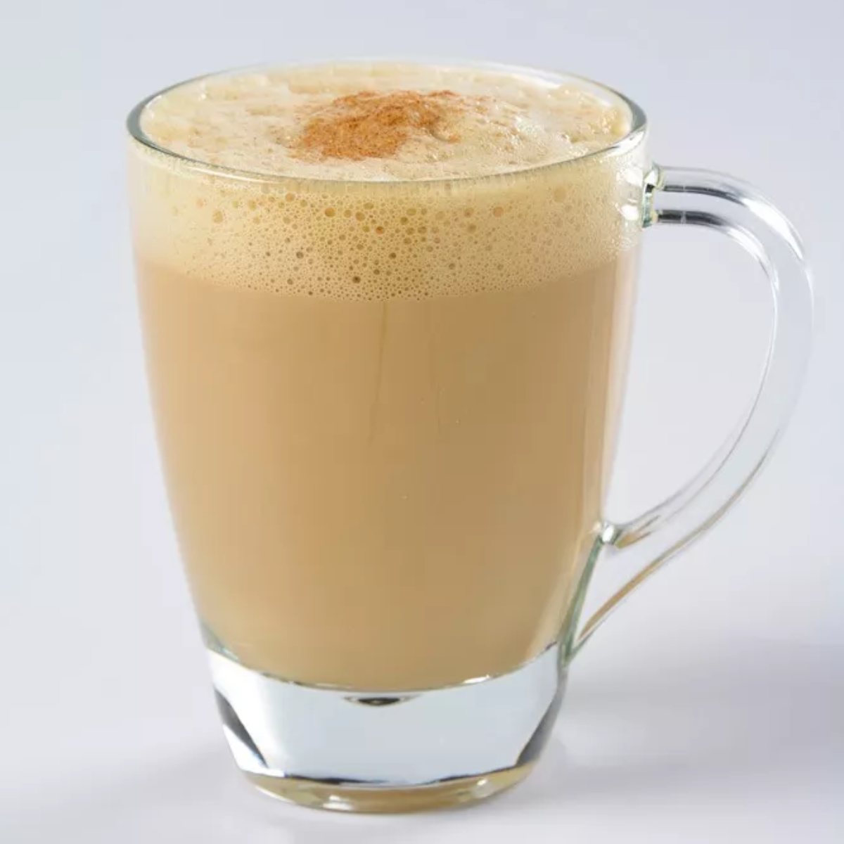 Taza de vidrio Pergamino con capuchino espumoso, perfecta para bebidas calientes.