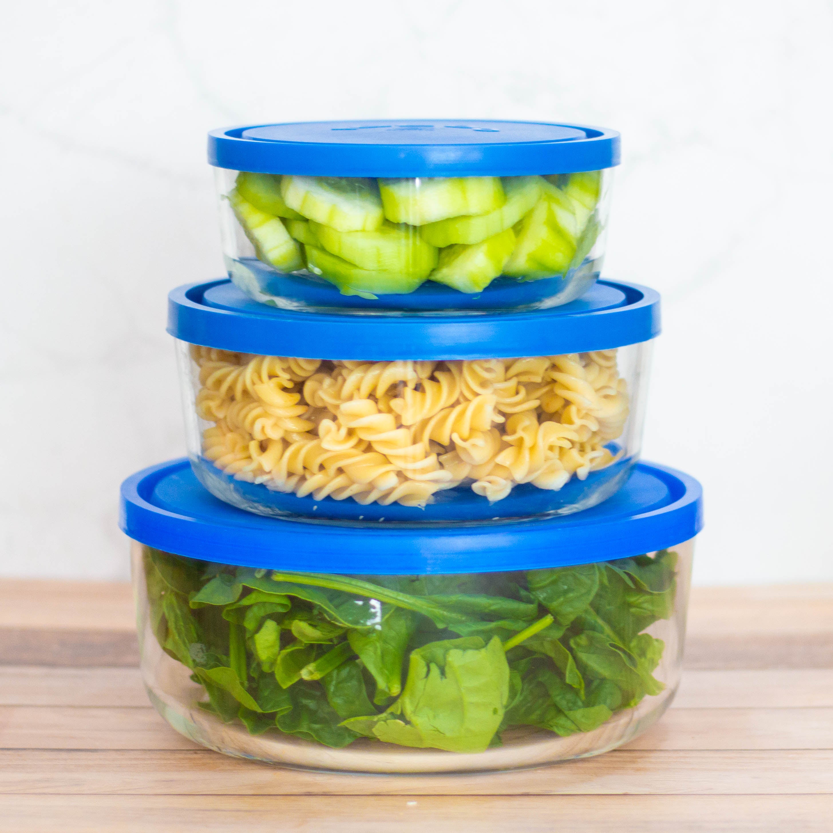 contenedores con tapa ampliables de vidrio con alimentos variados en su interior, como pasta o verdura