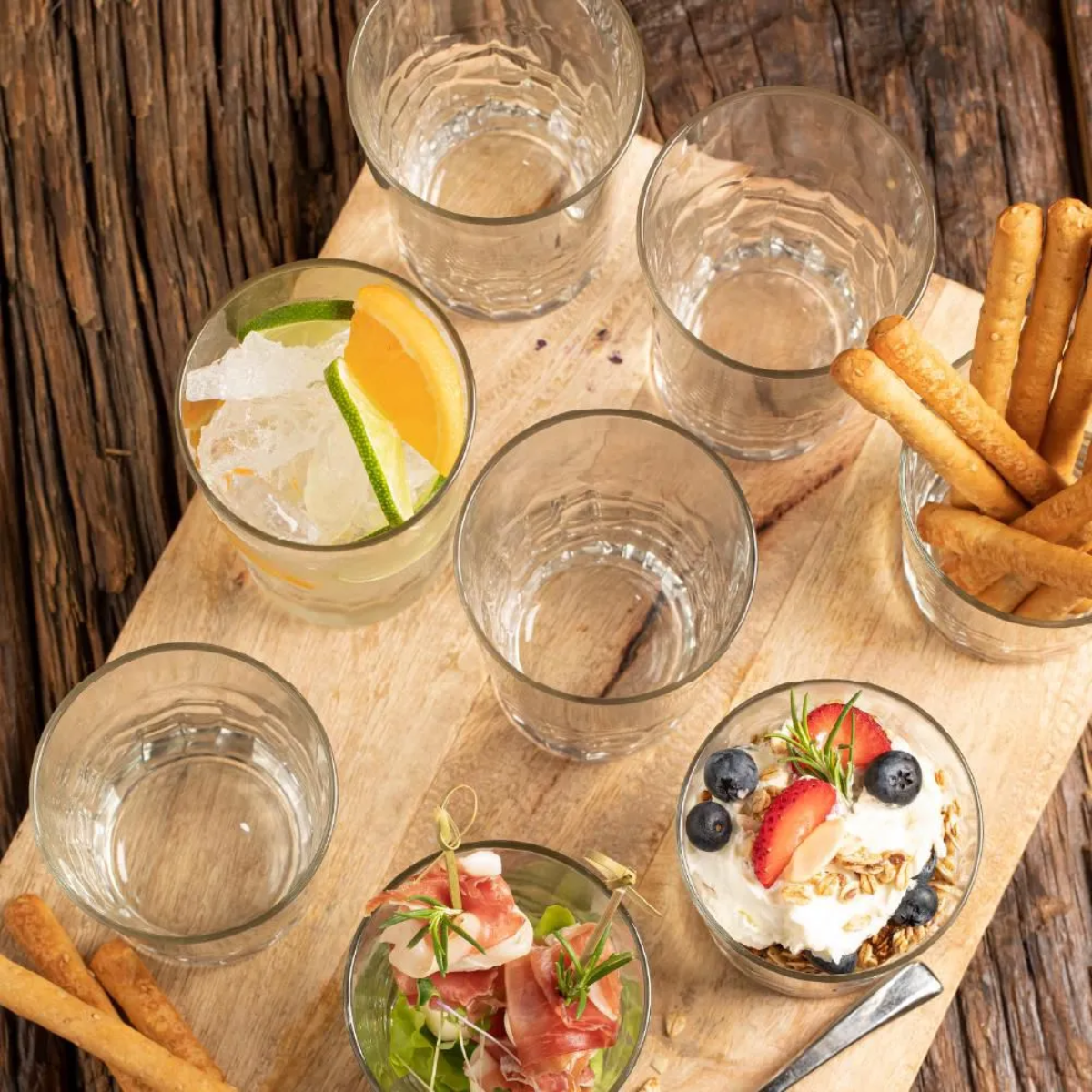 Vasos Old Fashioned Tierra con bebidas y aperitivos en mesa de madera