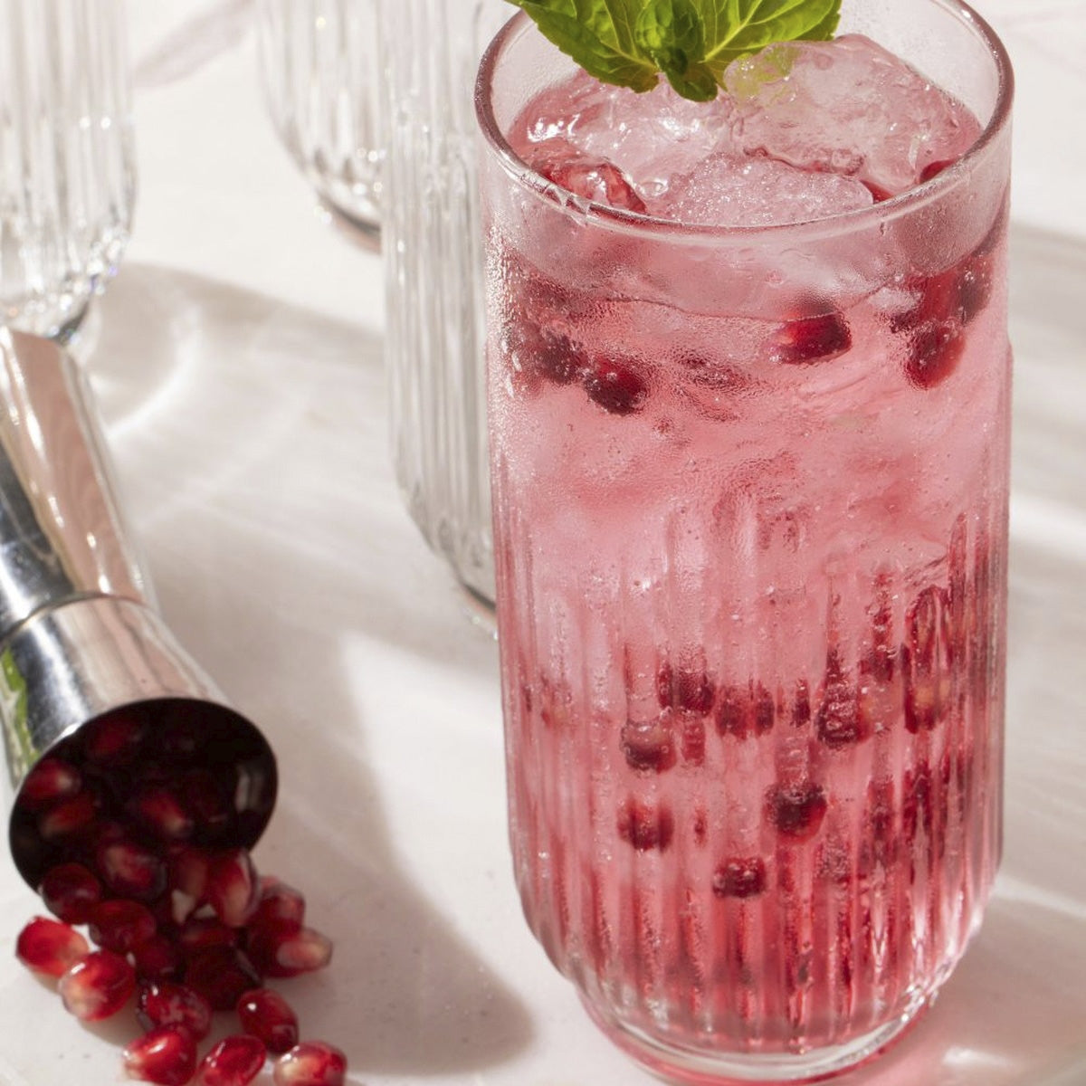 Vaso alto de vidrio estriado Barcelona con bebida frutal rosada