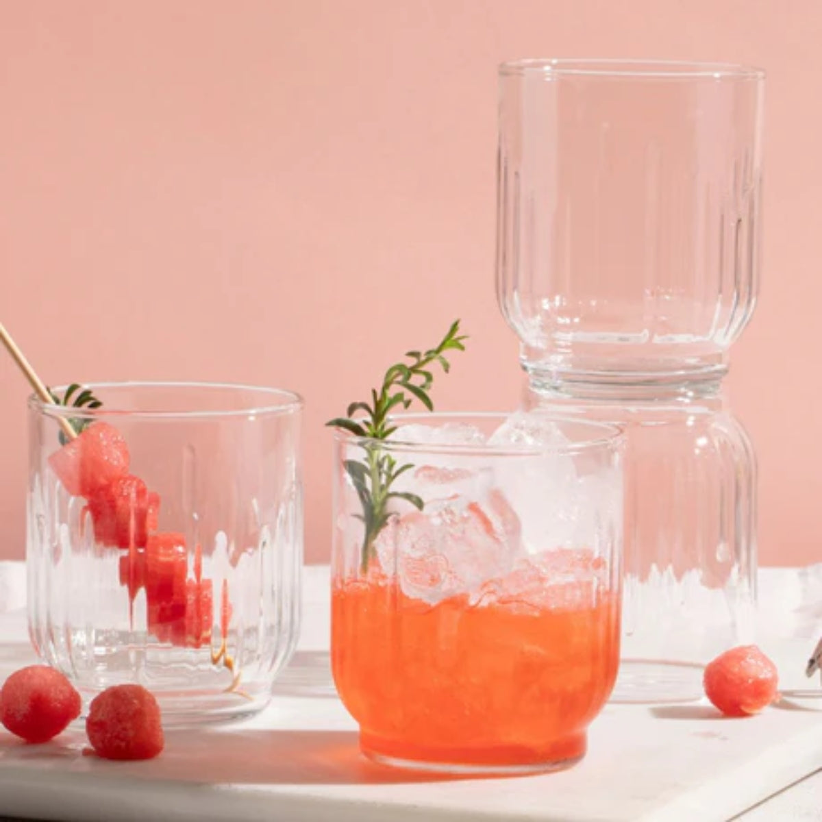 Vasos de vidrio Barcelona altos y bajos con bebidas en ambiente decorativo