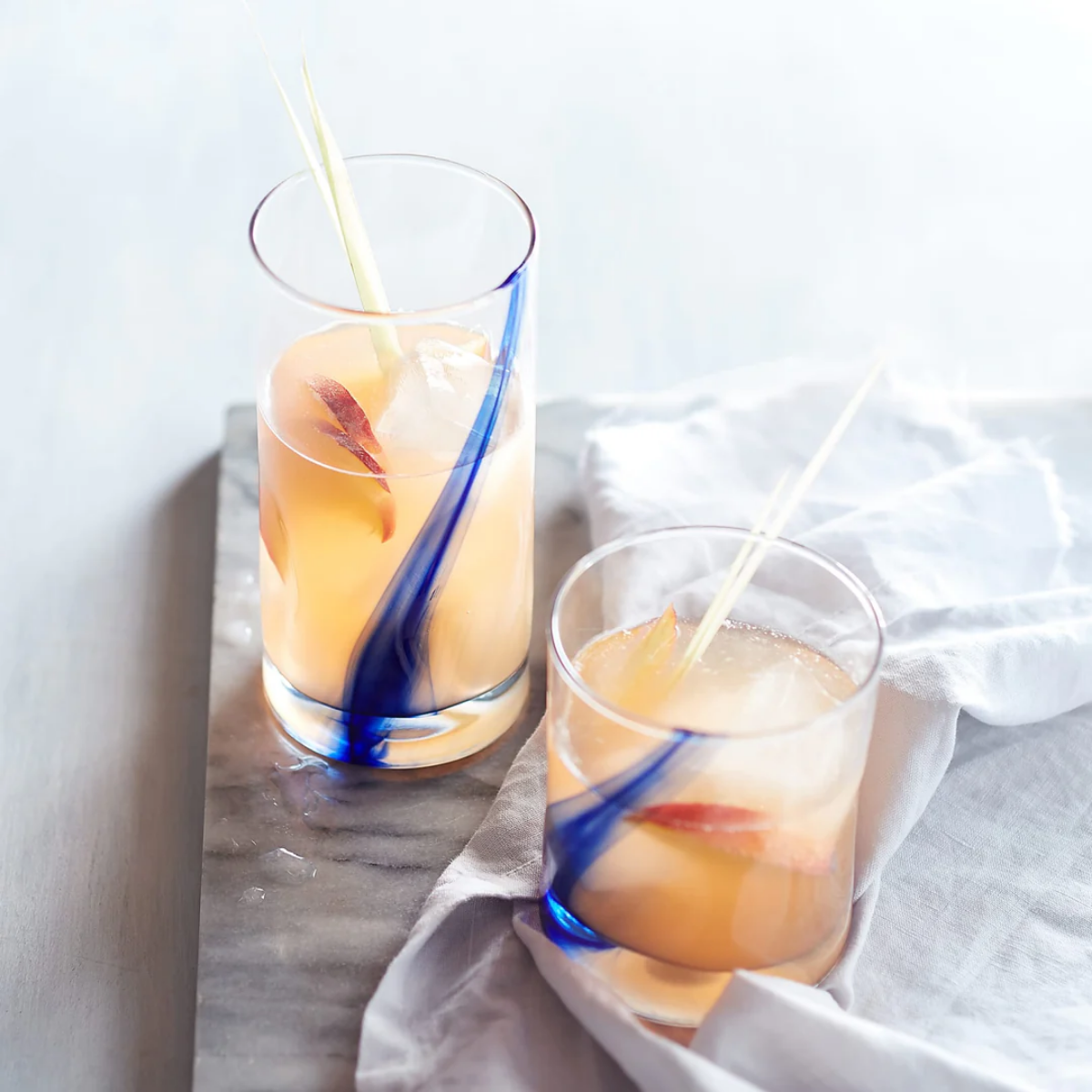 Vasos Ribbon de vidrio con coctel de manzana en mesa de comedor