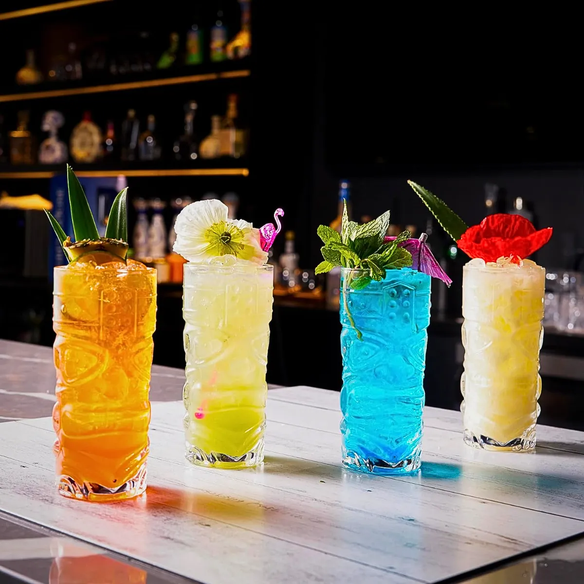 Set de vasos Tiki Taka Hawaii con cócteles tropicales de colores en barra
