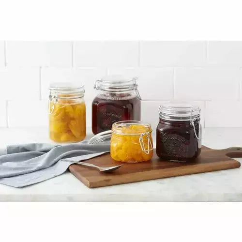 contenedores de vidrio con mermelada en una tabla de madera ambientada en una cocina