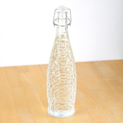 Botella con cierre hermetico de vidrio en mesa de madera con agua